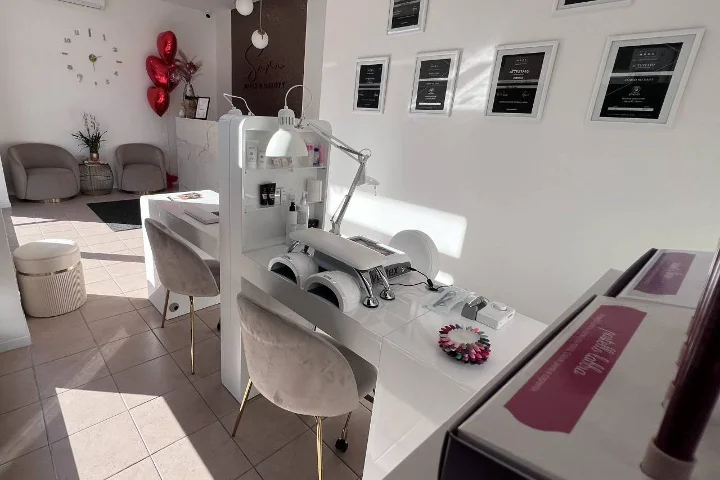 Witte nagelsalon Sara Nails&Beauty in Tortolì met grijze fluwelen stoelen en ingelijste certificaten aan de muur.