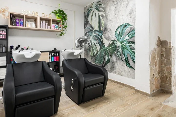 Wasstoelen en color bar bij Yourself in Tortolì met een tropische monstera-muurschildering.