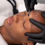 Close-up van een schoonheidsspecialist die dermaplaning uitvoert bij een klant in een salon