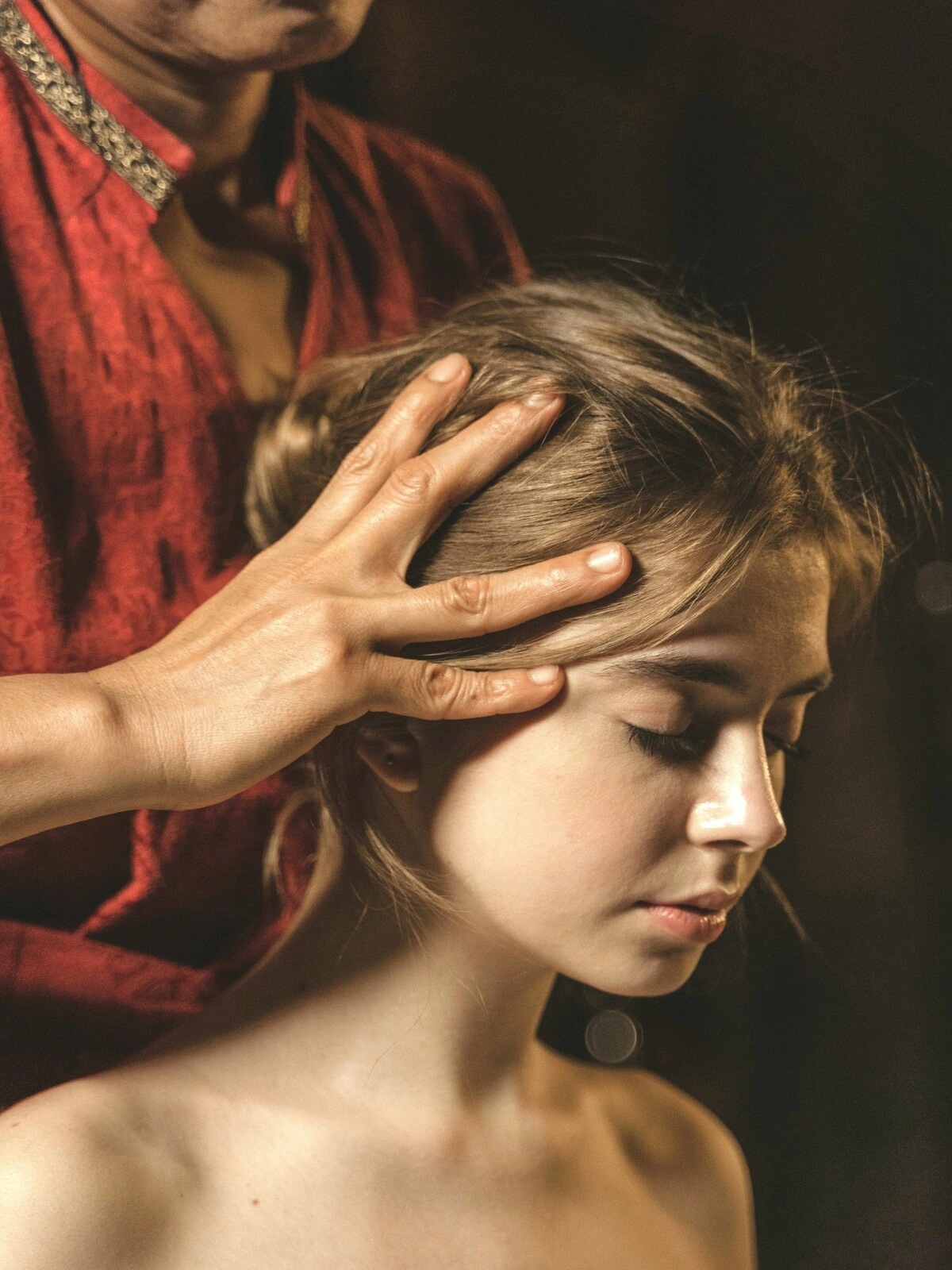 Close-up van een vrouw met haar ogen dicht terwijl een specialist tijdens een Indische hoofdmassage haar hoofdhuid masseert